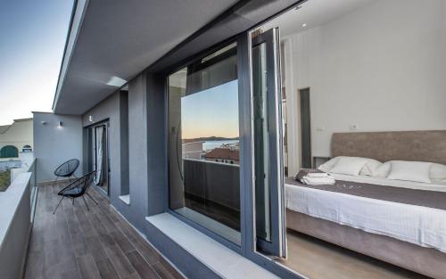 a bedroom with a bed and a large window at Villa Martinis in Rogoznica