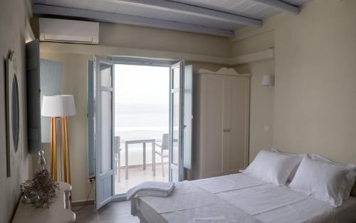 a bedroom with a bed with a view of the ocean at Makares in Donoussa