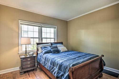 a bedroom with a bed with a blue comforter and a window at Cozy Greenville Bungalow about 2 Mi to Downtown! in Greenville