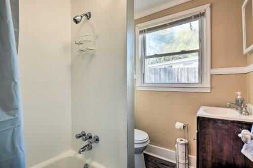 uma casa de banho com um WC, um lavatório e uma janela em Cozy Greenville Bungalow about 2 Mi to Downtown! em Greenville