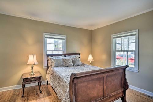 a bedroom with a bed and two windows at Cozy Greenville Bungalow about 2 Mi to Downtown! in Greenville