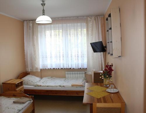 a small bedroom with a bed and a window at Hotel Sportowy in Ostrzeszów