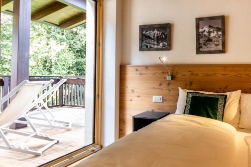 a bedroom with a bed and a balcony at Alpine View Plan de Corones in Sorafurcia