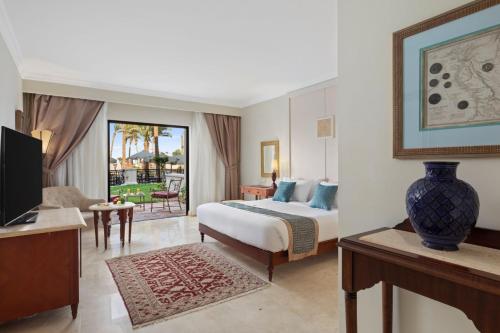 a hotel room with a bed and a television at Pickalbatros The Palace Port Ghalib in Port Ghalib