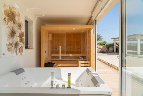 una cocina con una gran bañera blanca en una habitación en Villa Green - Sardegna en Calangianus