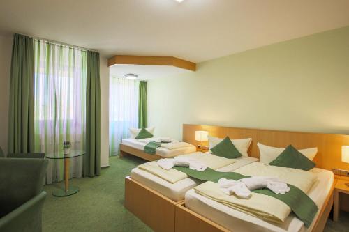 Cette chambre comprend deux lits et une télévision. dans l'établissement Panorama Hotel Winterberg, à Winterberg