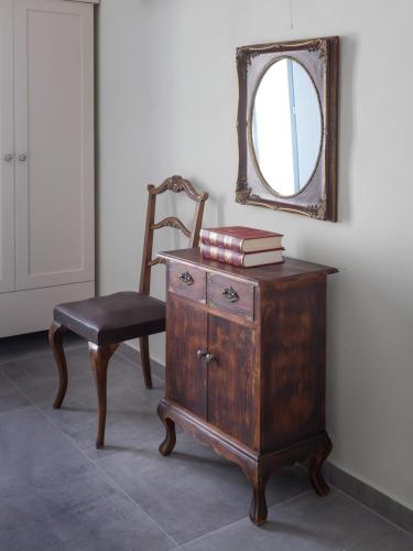 a chair and a dresser with a mirror on a wall at Makares in Donoussa