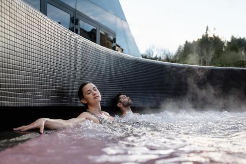 a man and a woman in a hot tub at Terme Olimia - Aparthotel Rosa in Podčetrtek