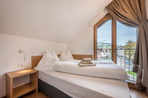 a bedroom with a bed with a large window at App Dolomiten Villa Colli in Valdaora