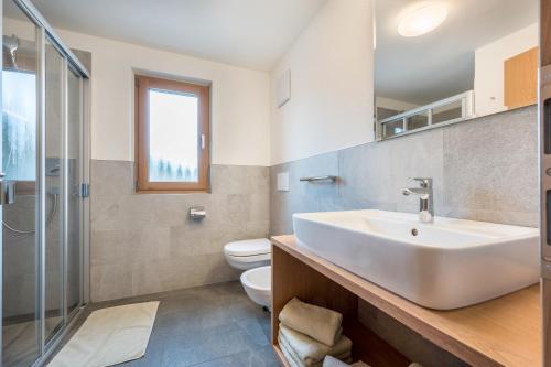 a bathroom with a sink and a toilet at App Dolomiten Villa Colli in Valdaora