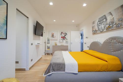 - une chambre avec un grand lit et une couverture jaune dans l'établissement Villa Green - Sardegna, à Calangianus
