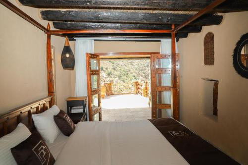 a bedroom with a bed and an open door at the suwgra-Al-Jabal Al-Akdar in Sūkirah