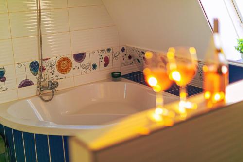 a bathroom with a tub with candles on a counter at Mártoni Villa in Szigetszentmárton