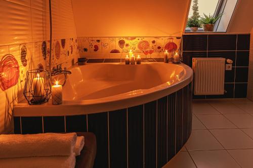 a bathroom with a large tub with candles in it at Mártoni Villa in Szigetszentmárton