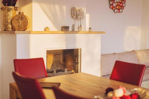 a living room with a table and a fireplace at Mártoni Villa in Szigetszentmárton