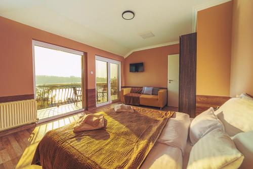 a bedroom with a large bed and a balcony at Mártoni Villa in Szigetszentmárton