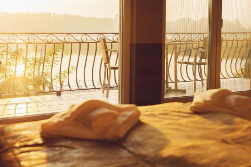 a bed in a room with a view of a balcony at Mártoni Villa in Szigetszentmárton