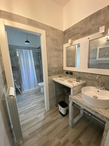 un bagno con lavandino, WC e specchio di La casa di Nina a Lecce