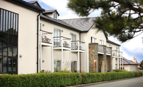 a row of white houses with balconies on a street at The Quay Hotel and Spa in Conwy