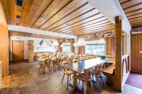 a dining room with wooden ceilings and tables and chairs at Heuberge in Fideris Dorf
