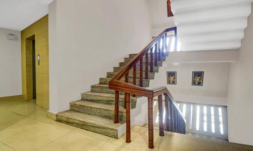 a staircase with wooden railings in a building at Treebo Darwesh Residency - 500m from Railway Station in Kozhikode