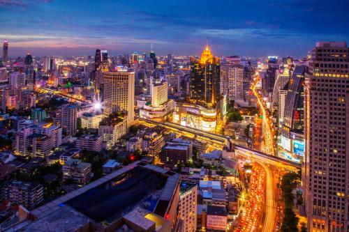 a city lit up at night with traffic at Column Bangkok Hotel in Bangkok