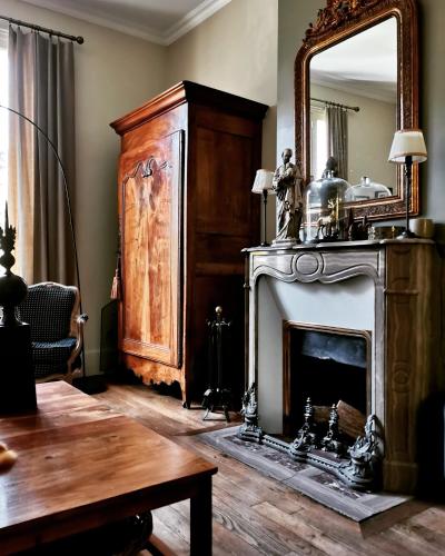 un salon avec une cheminée et un miroir dans l'établissement La Maison de Ville, à Compiègne