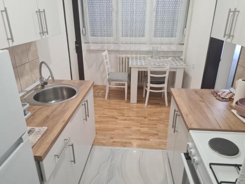 una pequeña cocina con fregadero y mesa en Stan na dan 50 BAM en Prijedor
