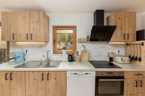 a kitchen with wooden cabinets and a sink at Captain's Lodge in Bohinj