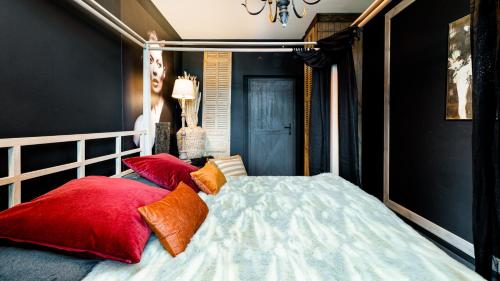 a bedroom with a bed with red and orange pillows at VacationClub - Kościelna 2 Apartament 4 in Karpacz