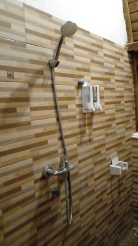 y baño con ducha y pared de madera. en The Hill Prananta, en Polilit