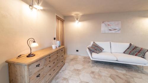 a living room with a white chair and a dresser at Ca' Ginet in Cravanzana