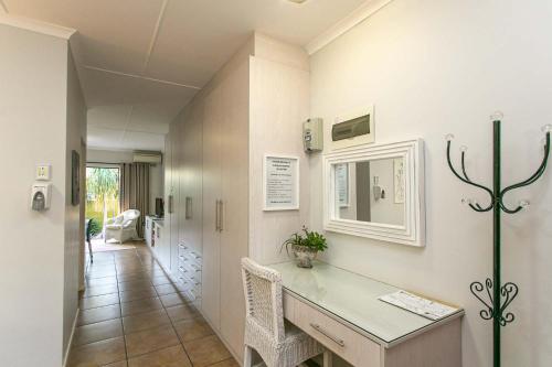 a hallway with a desk and a mirror on the wall at Eldorado Private Collection in Oudtshoorn