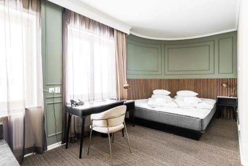Comfort Hotel Linköping City في لينكوبِنغ: غرفة فندقية بسريرين ومكتب