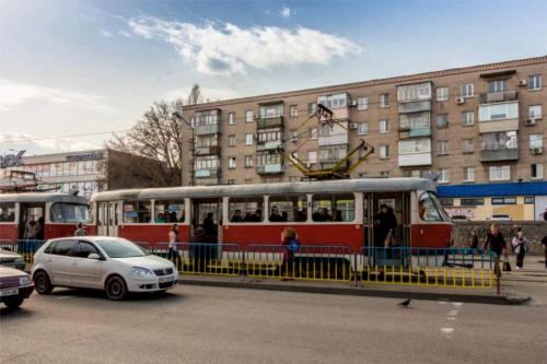 um autocarro vermelho e branco estacionado em frente a um edifício em Апартаменты Амстердам проспект Богдана Хмельницкого em Dnipro