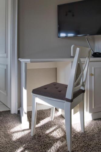 a white desk with a chair next to a table at Fitschen am Dorfteich in Wenningstedt