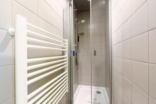 a shower stall with a toilet in a bathroom at MEININGER Hotel Dresden Zentrum in Dresden