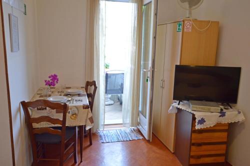 sala de estar con mesa, TV y comedor en Apartment Vivoda, en Opatija