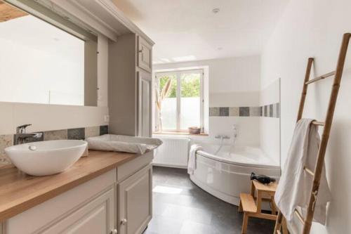 uma casa de banho com uma banheira e um lavatório e uma banheira em Normandy holiday cottage 'Le Papillon' em Neufchâtel-en-Bray