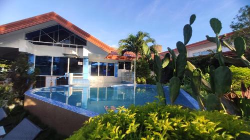 a villa with a swimming pool in front of a house at SEAVIEW BEACH RESORT in Sibulan