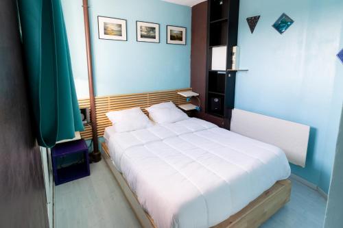 - une chambre bleue avec un lit blanc dans l'établissement Havre de paix à deux pas de la plage - Arrivée autonome, Parking privé et gratuit, à Varaville