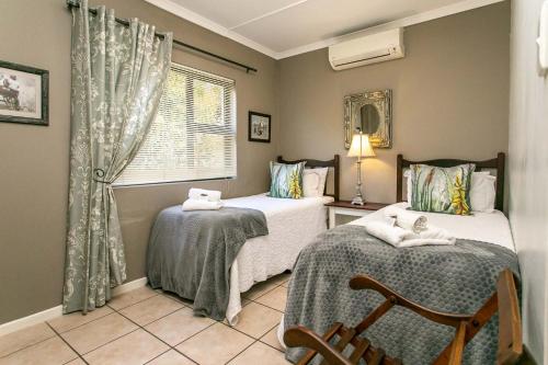 um quarto com 2 camas e uma janela em Eldorado Private Collection em Oudtshoorn