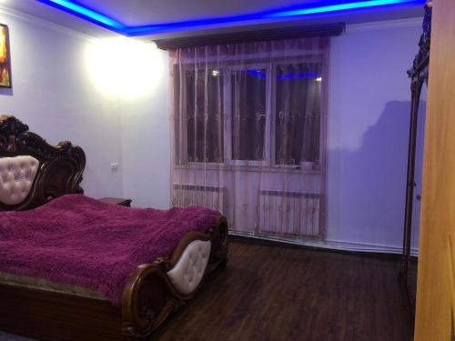 - une chambre avec un lit et une couverture violette dans l'établissement Yerevan Qanaqer House, à Erevan