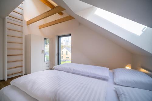 a bedroom with a white bed and a window at Holiday House U Hájenky 13P Lipno Home in Lipno nad Vltavou