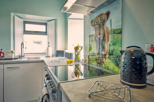 una cocina con una barra con una jarra en un mostrador en Host & Stay - Bluebell Cottage en Belford