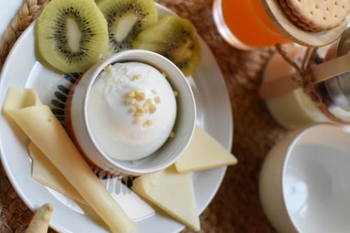 a plate of food with kiwi cheese and a cup of yogurt at queen 24 in Taranto