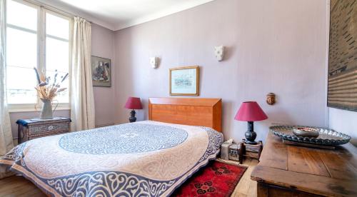 une chambre avec un lit et deux lampes et une fenêtre dans l'établissement Appartement confortable à Saumur de 105 m², à Saumur
