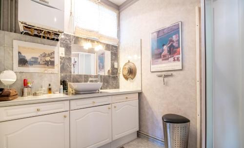 ein Bad mit einem Waschbecken und einem Spiegel in der Unterkunft Appartement de 2 chambres avec vue sur la ville et wifi a Saumur in Saumur