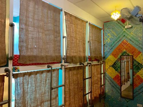 パングラオにあるムーン フールズ ホステルのバスルーム(茶色のカーテン、鏡付きの壁付)