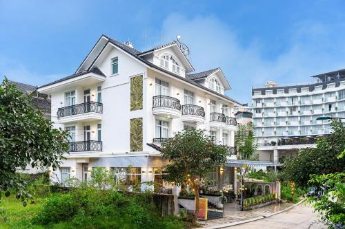 大叻的住宿－Dalat Wind Hotel，带阳台的白色建筑和酒店